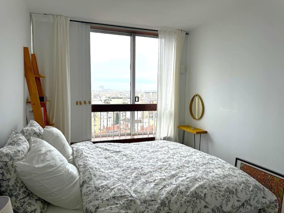 une chambre avec un lit et une grande fenêtre dans l'établissement A cozy Parisian apartment close to Eiffel Tower, à Paris