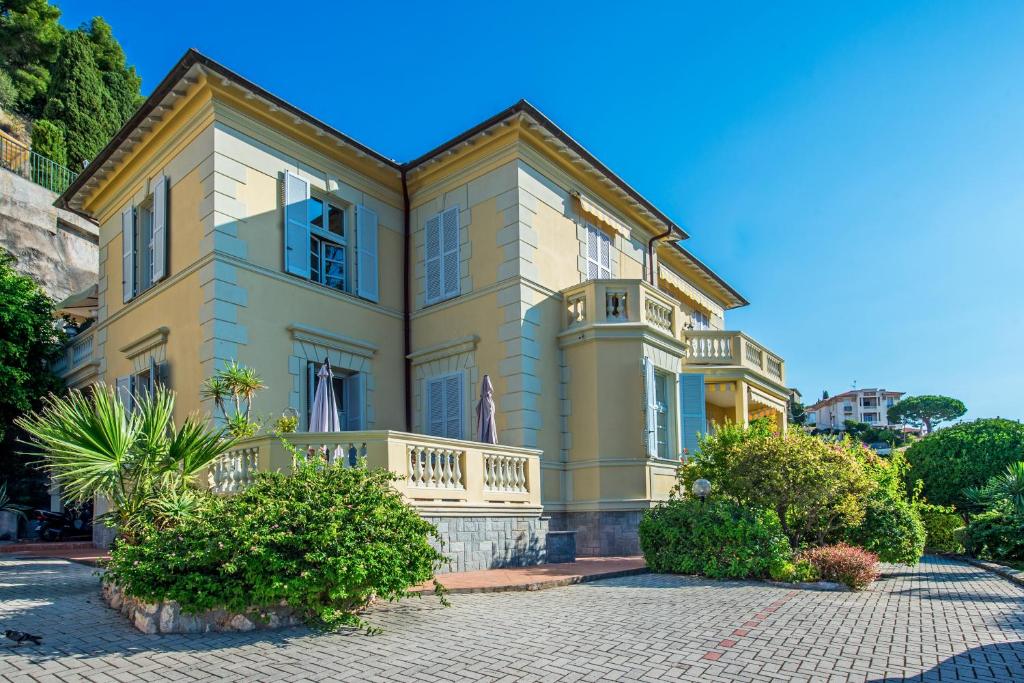 une grande maison jaune avec un balcon dans l'établissement OLIVIERS -Agréable 2 pièces dans maison bourgeoise, à Menton