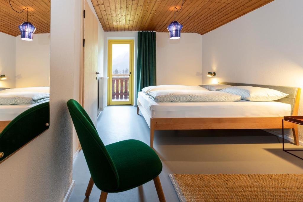 una camera con due letti e una sedia verde di MiraOdle Apartments a Villnoss