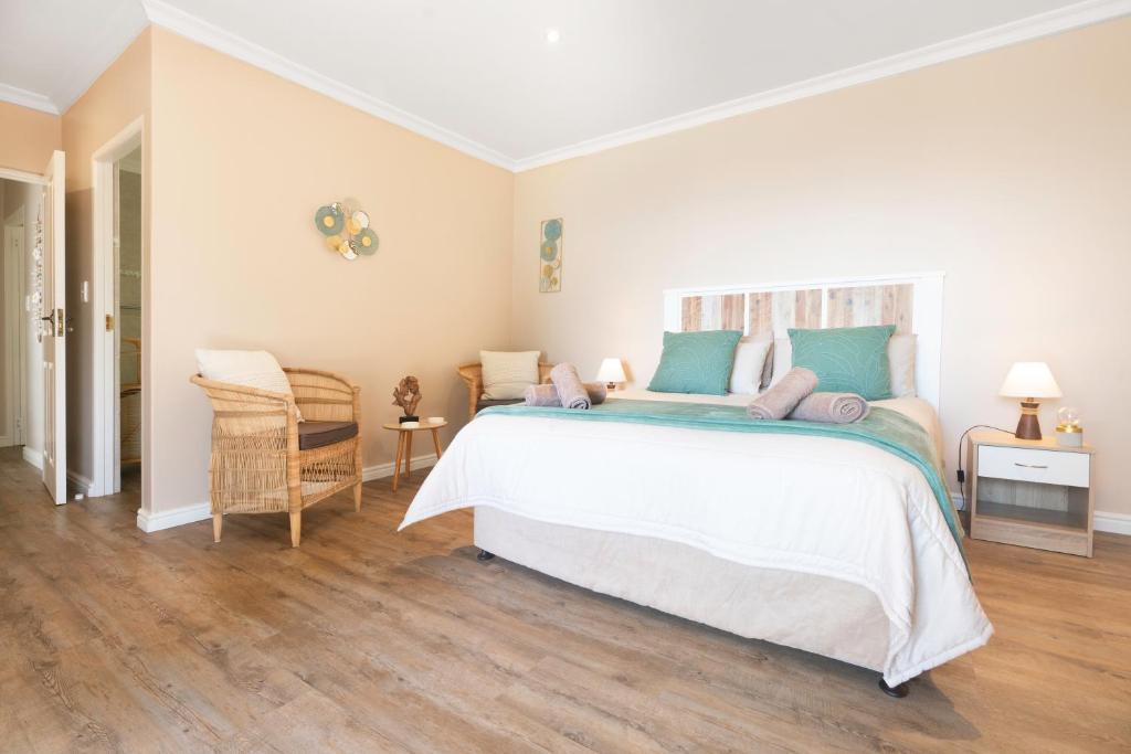 a bedroom with a large white bed with blue pillows at Coney Glen Cottage in Knysna