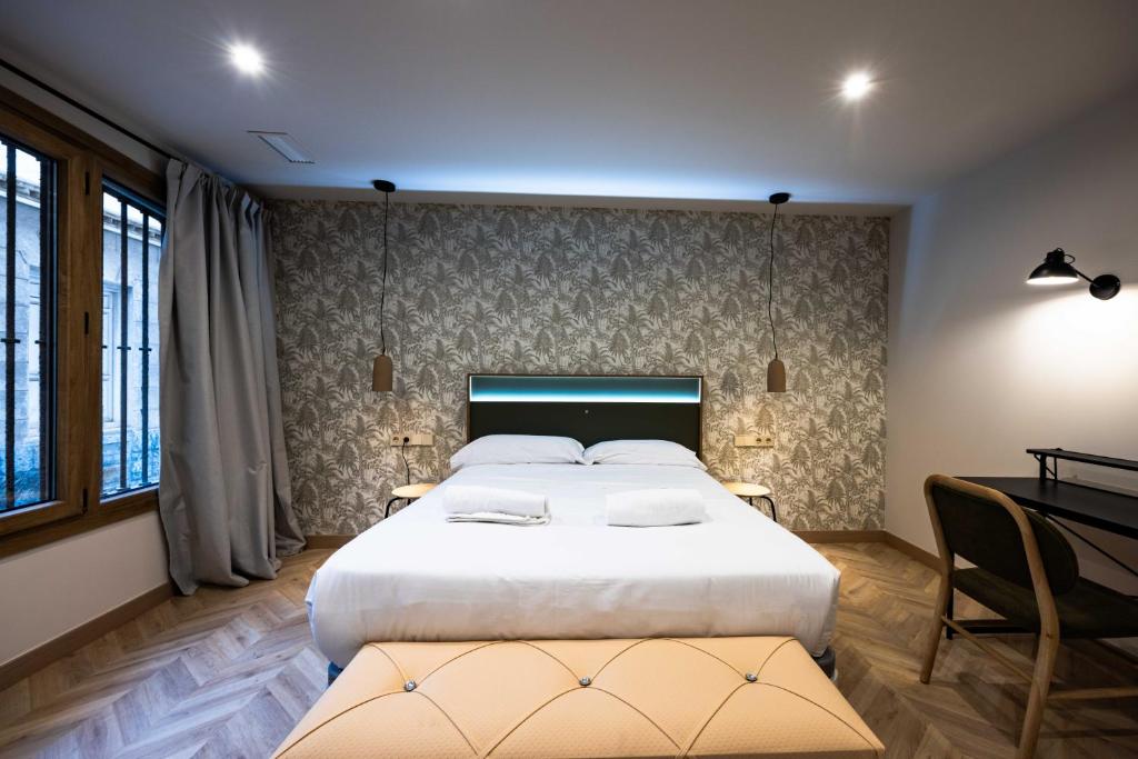 a bedroom with a large white bed and a desk at Apartamento Turístico Royal, by CartagenaSpain in Cartagena