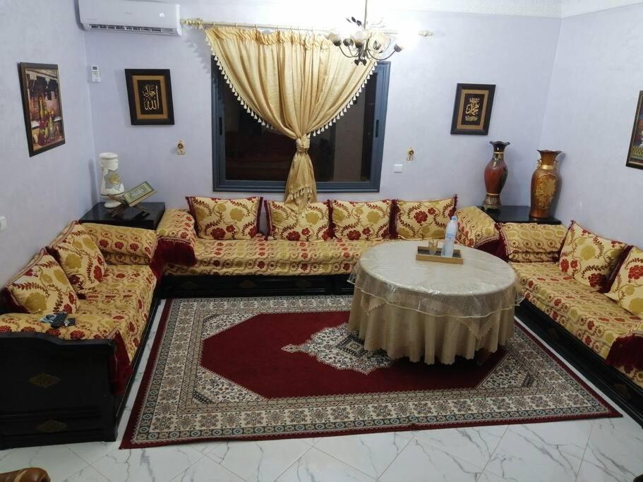 un salon avec un canapé et une table dans l'établissement Appartement pour famille, à Agadir