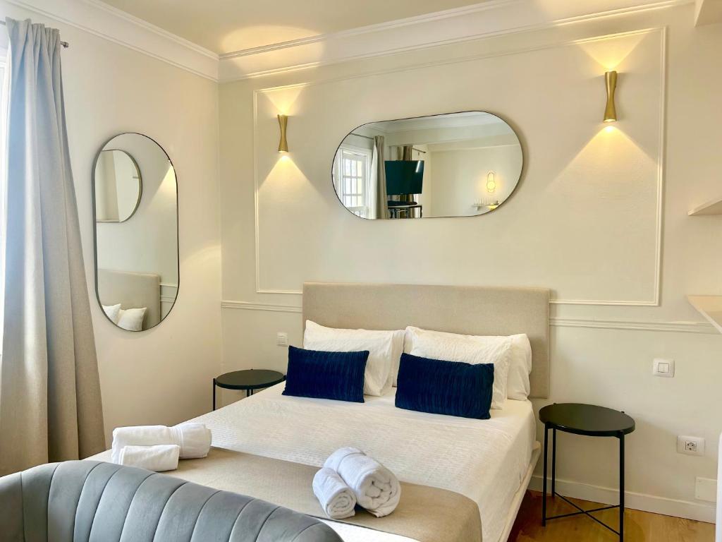 a bedroom with a bed with blue pillows and mirrors at Art déco in Santa Cruz de la Palma