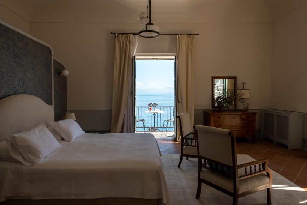 a bedroom with a bed and a view of the ocean at Tonnara di Scopello in Castellammare del Golfo
