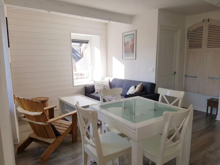 un salon avec une table et des chaises blanches dans l'établissement Loue appartement 50m de la plage 2 ch 4 ou 5 pers, à Pléneuf-Val-André