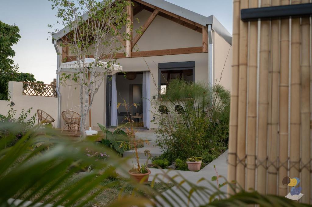 a house with a garden in front of it at L'oasis 3 étoiles - Lodge 2 - DODOTERLA in Le Tampon