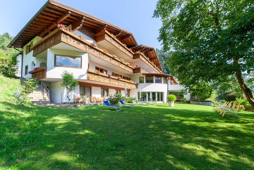 a large house with a green lawn in front of it at Hotel St. Pankraz in San Pancrazio dʼUltimo
