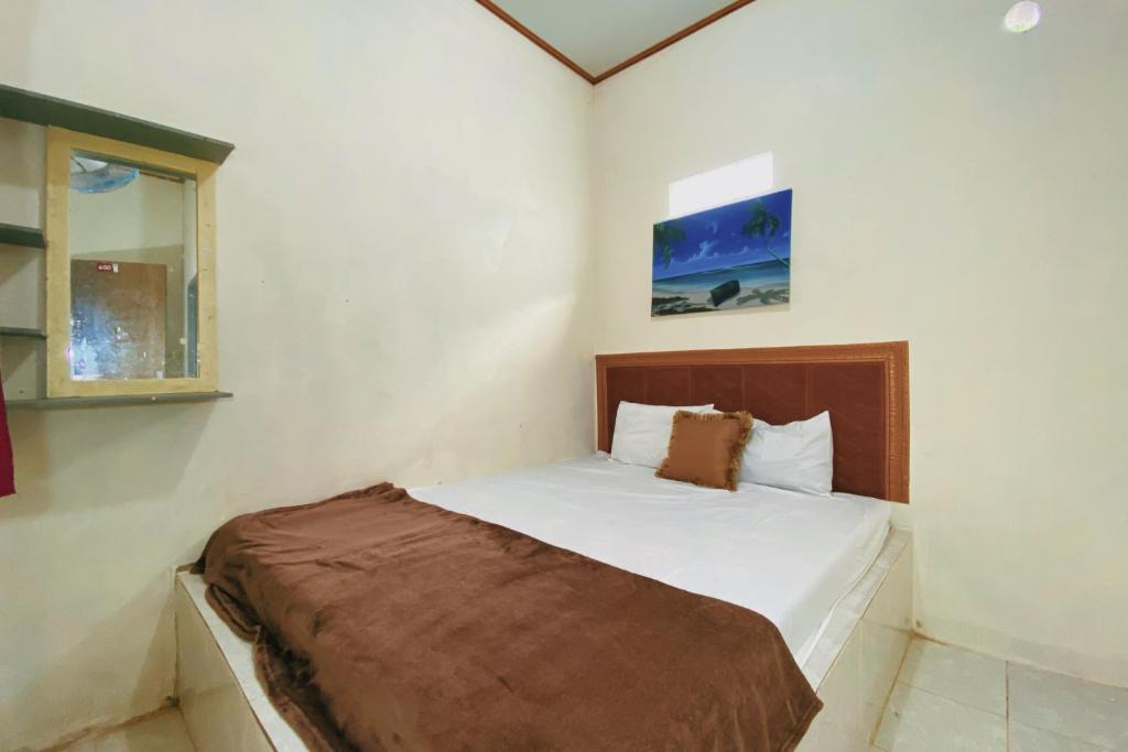 un dormitorio con una cama en una habitación en Central House Karimunjawa Mitra RedDoorz, en Karimunjawa