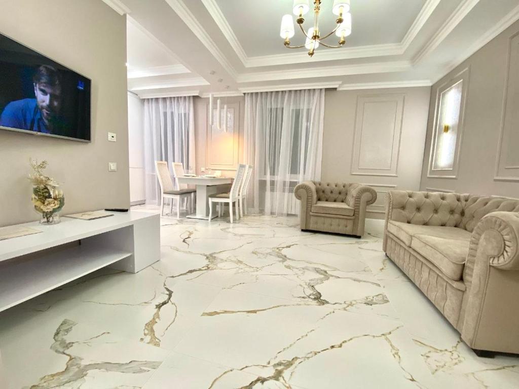 un soggiorno con un divano e un tavolo di ApartPoltava NEW PALACE 2023 Вишукані апартаменти на Соборності Центр Готельні чеки a Poltava