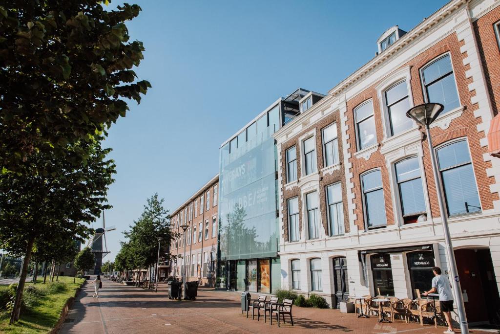 a city street with buildings and tables and chairs at Aparthotel Jacques van Marken Erfgoed in Delft