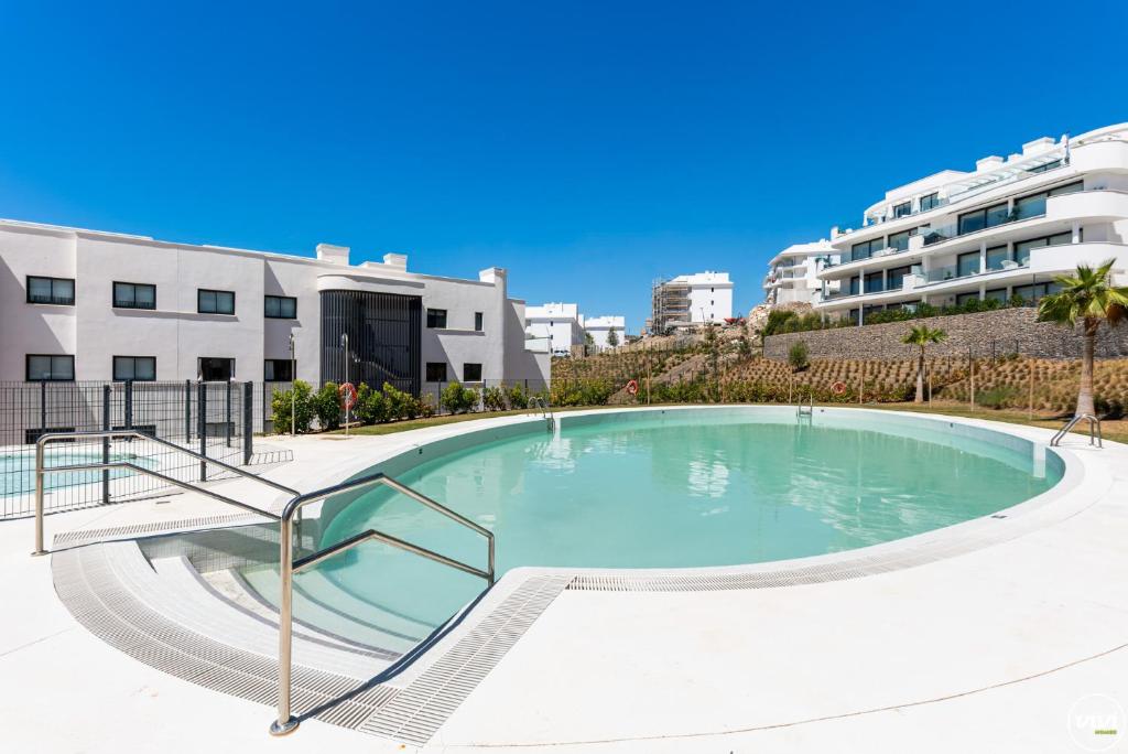 a large swimming pool in the middle of a building at ViVi Homes - El Valle Pool & Sea View in Fuengirola