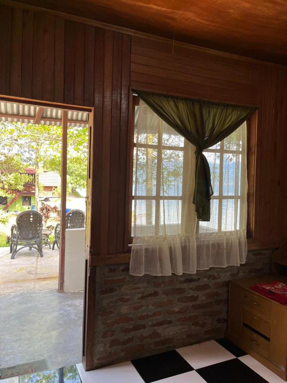 a room with a window and a patio at Eka's Bungalows in Maninjau