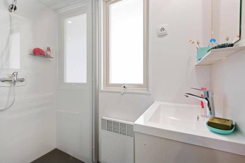 a white bathroom with a sink and a shower at Camping Capfun La Bretèche in Les Épesses