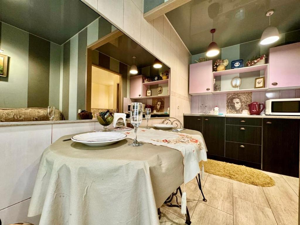 a kitchen with a table with a white table cloth at ApartPoltava Французький шик у центрі Полтави, 4 спальних місця, Корпусний парк in Poltava