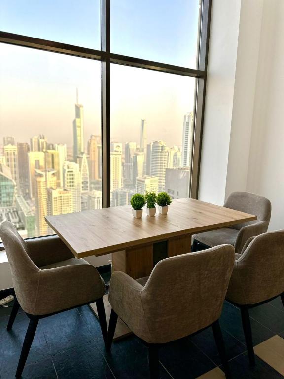 ein Tisch und Stühle in einem Raum mit einem großen Fenster in der Unterkunft Ora Place JBR in Dubai