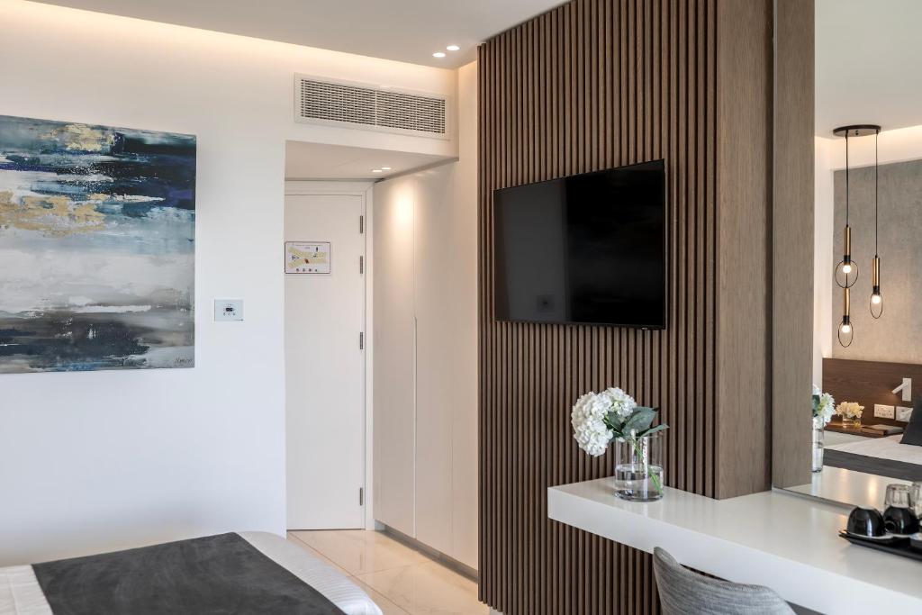 a living room with a television on a wall at Pavlo Napa Beach Hotel in Ayia Napa