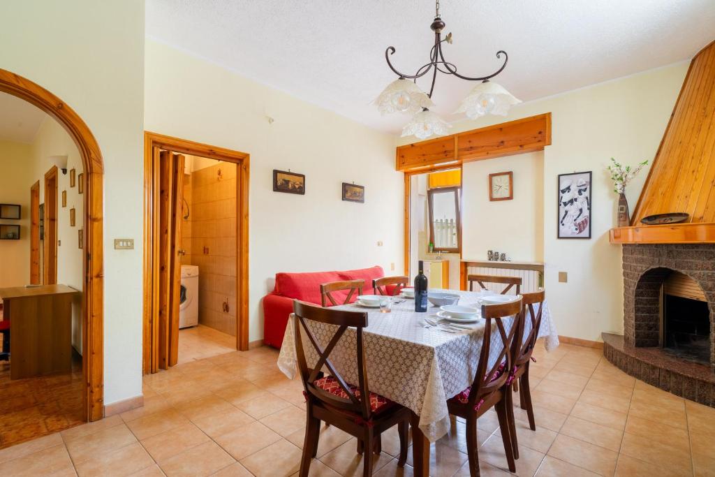 a dining room with a table and a fireplace at Appartamento Maria a Racale in Racale