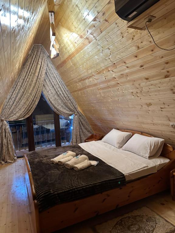 sypialnia z łóżkiem w drewnianej ścianie w obiekcie Sunny Cottage w mieście Martwili
