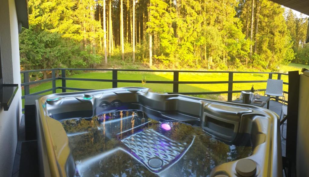 a bath tub with a view of a forest at Cozy Forest Wellness Suite in Saint-Vith