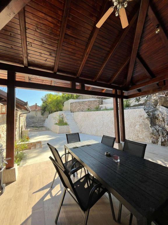 a wooden table and chairs on a patio at Kamena Idila in Stolac