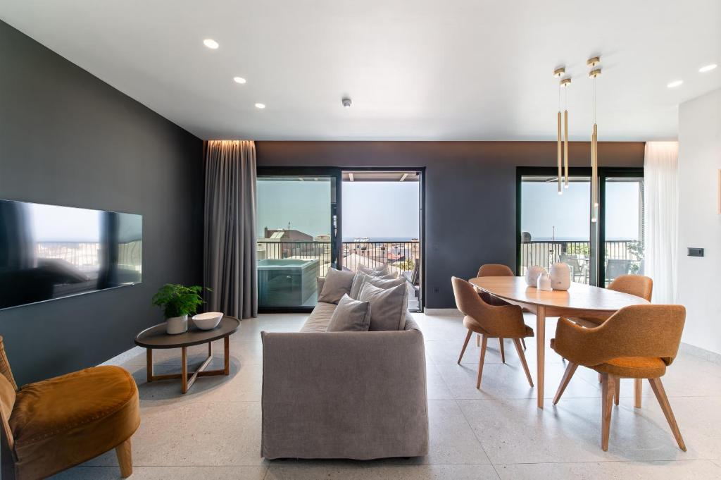 a living room with a couch and a table and chairs at Porta Suites in Heraklio