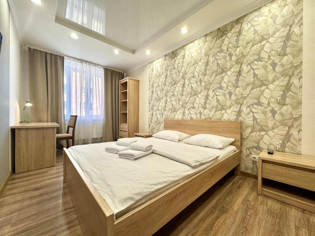 a bedroom with a bed and a stone wall at ApartPoltava Cучасні 2-кімн апартаменти з великою кутовою ванною ЦЕНТР МІСТА in Poltava