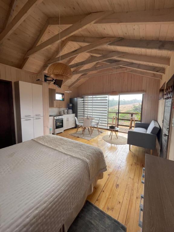 a bedroom with a bed and a living room at Cabaña Pangal in Pichilemu