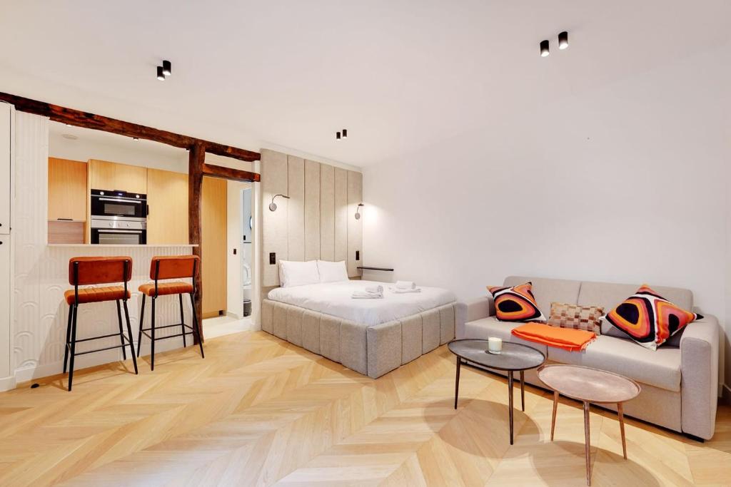 Il comprend un salon avec un canapé et un lit ainsi qu'une cuisine. dans l'établissement Saint-Honore - Sublime appartement 3 personnes, à Paris