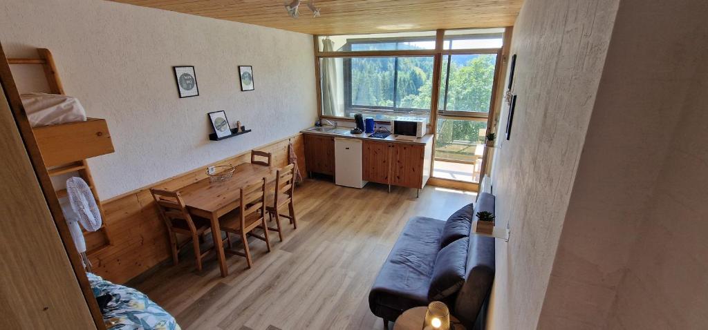 - un salon avec un canapé et une table à manger dans l'établissement Le Belle-Hutte, à La Bresse