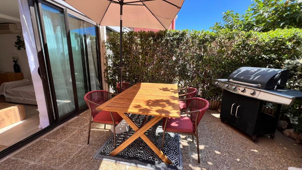 d'une table, de chaises et d'un barbecue sur la terrasse. dans l'établissement Joli appartement T2 climatisé, au Barcarès