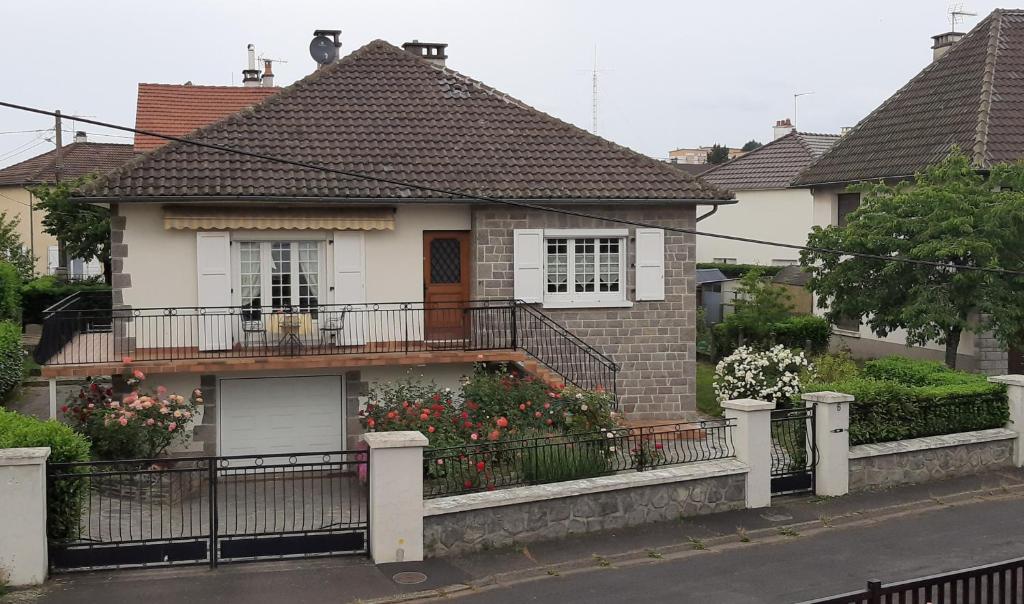 une maison avec un balcon fleuri dans l'établissement L'Enclos des Lys STUDIO, à Aurillac
