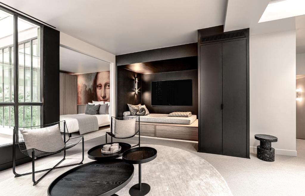 un salon avec un lit, une table et des chaises dans l'établissement Luxury Residence in old Marais, 3 BR, Patio, Sauna, Fitness Room, AC, à Paris