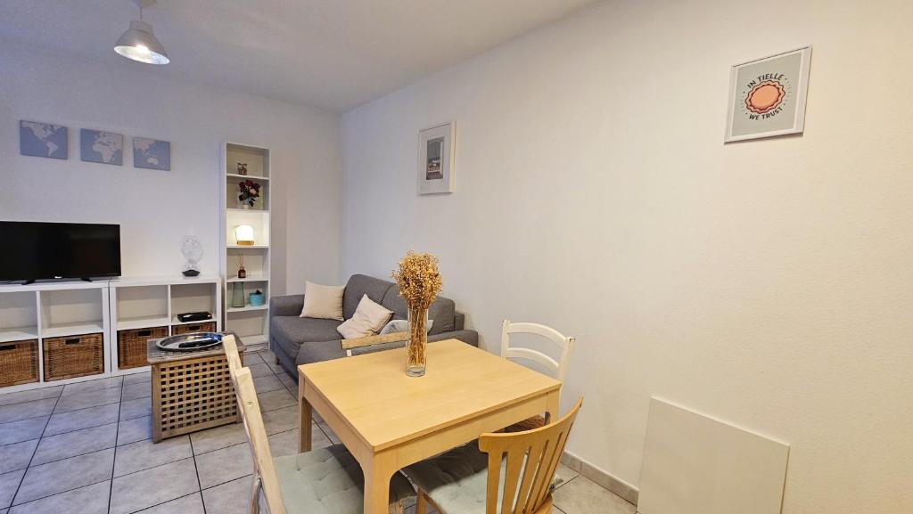 un salon avec une table et un canapé dans l'établissement Charmant T2 au coeur de Sète avec terrasse !, à Sète