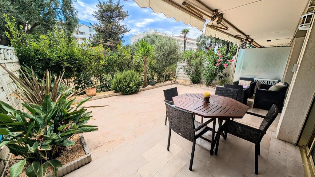 un patio avec une table, des chaises et des plantes dans l'établissement Ref SOPHIA by Palmes dProperties, à Cannes