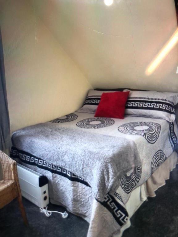 a small bedroom with a bed with a red pillow at Blue Room, twin in London