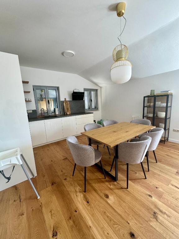 a dining room with a wooden table and chairs at NINOA holidays in Petrcane