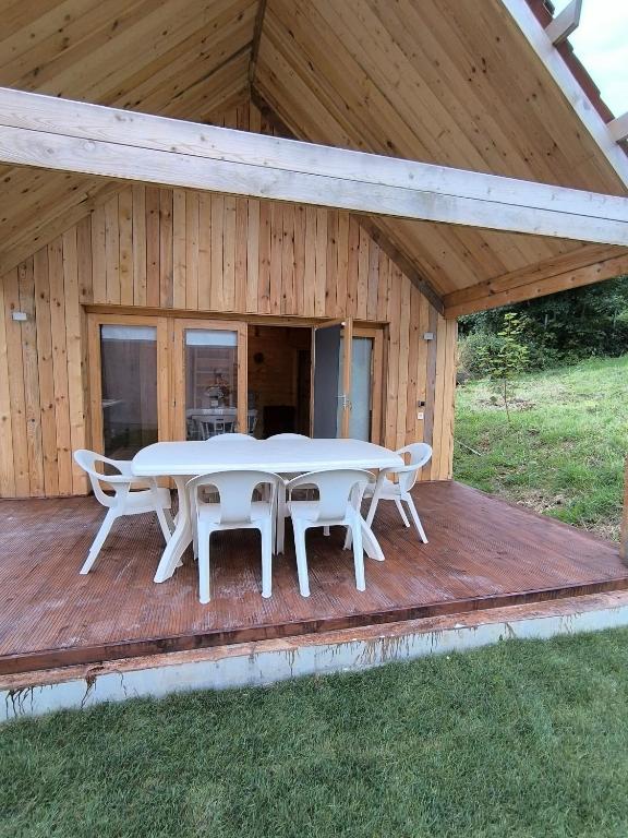 une terrasse en bois avec une table et des chaises dessus dans l'établissement Le nid nature et bonheur, à Neufchâtel-Hardelot