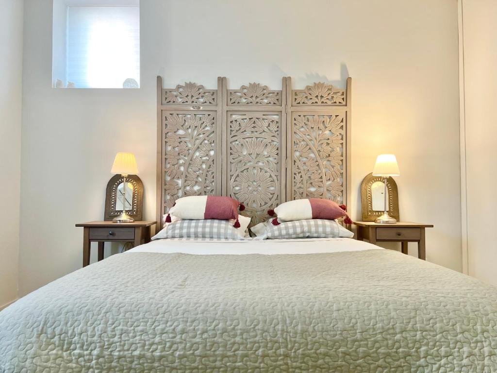 a bedroom with a large white bed with two mirrors at Fleur de Lis in Belas