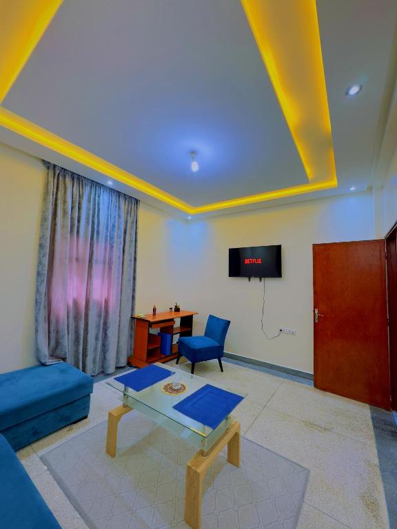 アガディールにあるQuiet Central Home Near Beach - High Speed WiFi, Free Parking & Private Entryの青いソファとテレビのあるリビングルーム