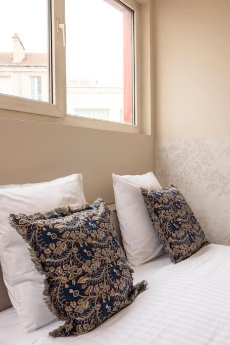 une chambre avec un lit avec des oreillers et une fenêtre dans l'établissement Studio paisible et confortable Paris 19, à Le Pré-Saint-Gervais
