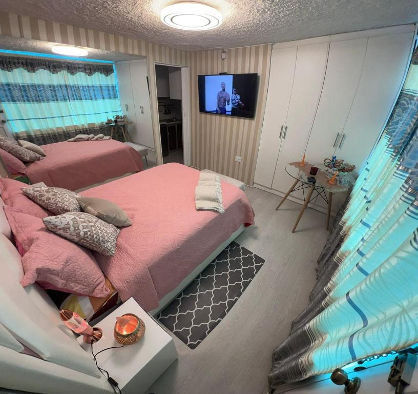 una camera da letto con due letti e una TV a schermo piatto di Gold House Oro a Hacienda Mera