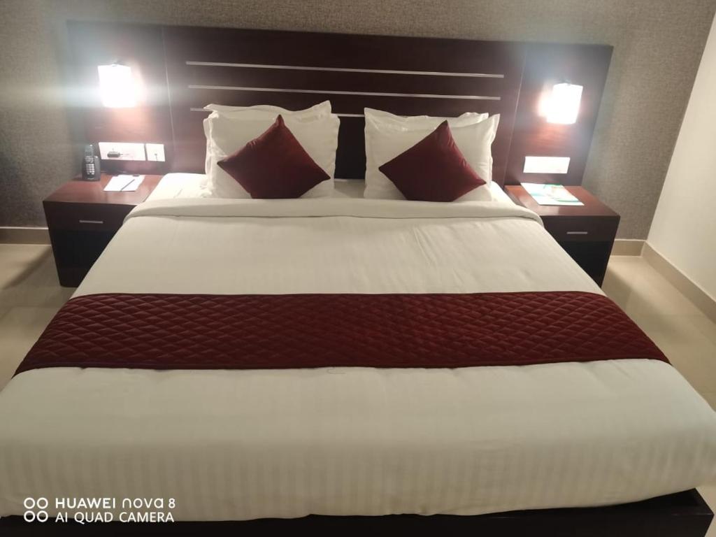 KottaraHotel Emerald Gardens的卧室里有一张大床，配有红白相间的枕头