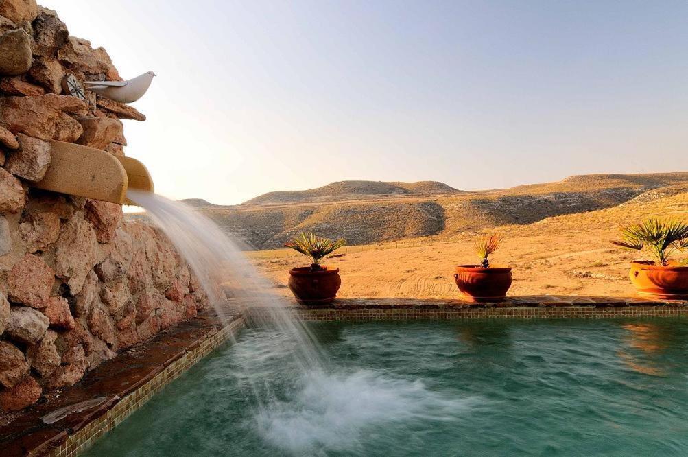 einen Brunnen mit Topfpflanzen an der Wand in der Unterkunft Cortijo La Joya de Cabo de Gata in Agua Amarga