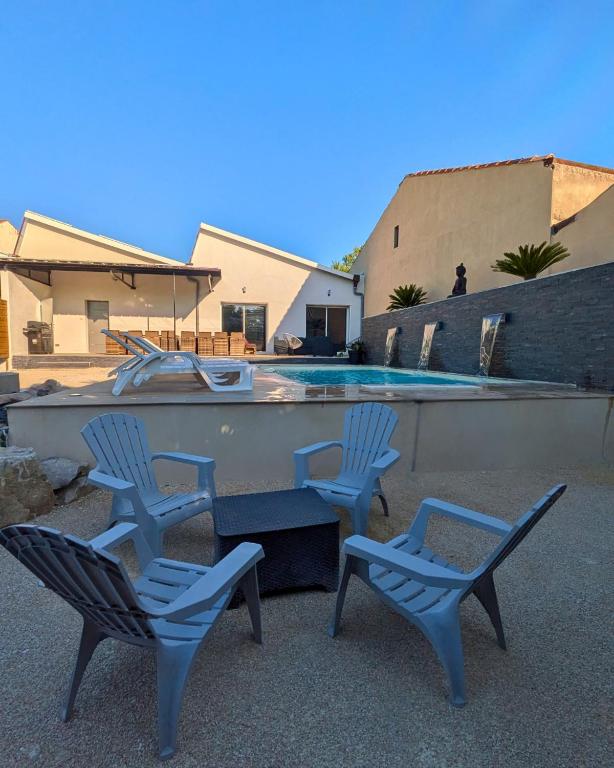 two chairs and a table next to a pool at Loft entre vignes et truffes - Gite en Provence Vaucluse in Valréas