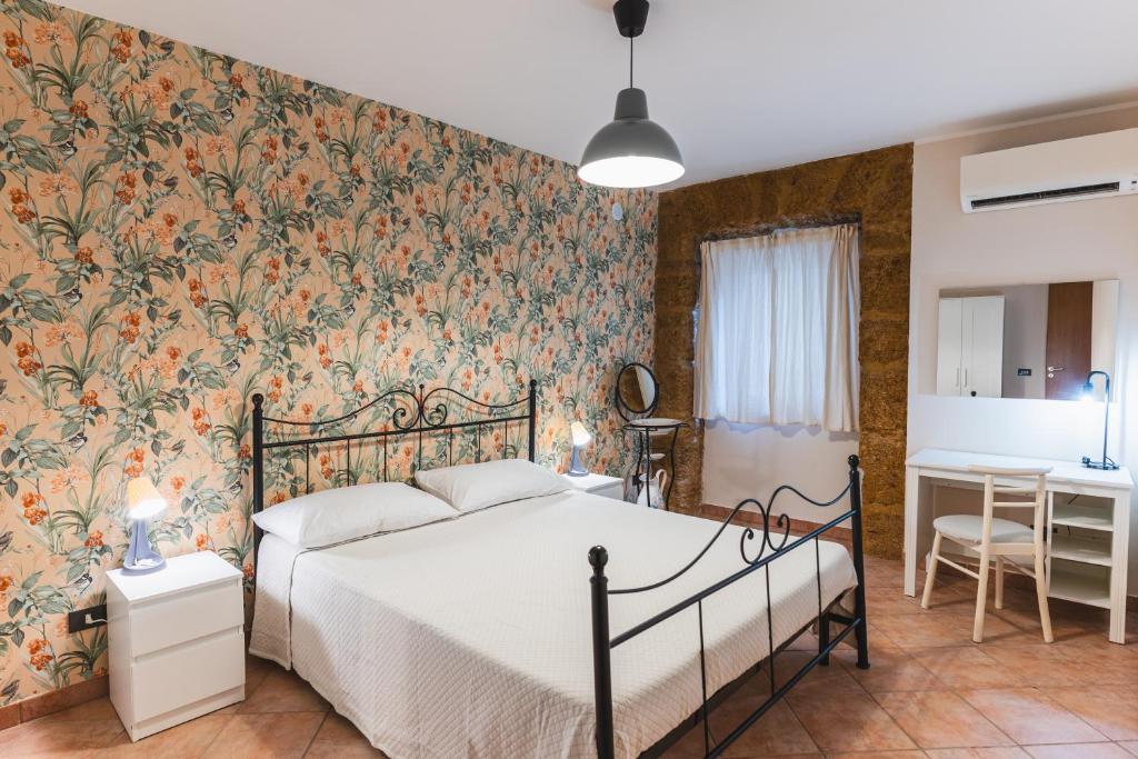 una camera da letto con un letto e carta da parati floreale di I Cardilli di San Lorenzo a Agrigento