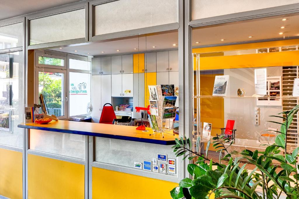 an office with a yellow and blue counter with red chairs at Hotel ISG Heidelberg in Heidelberg