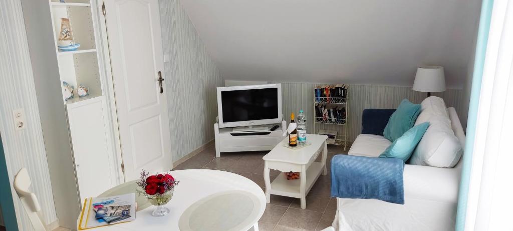 a small living room with a couch and a tv at Ferienwohnung Schmetterling II in Grossenbrode