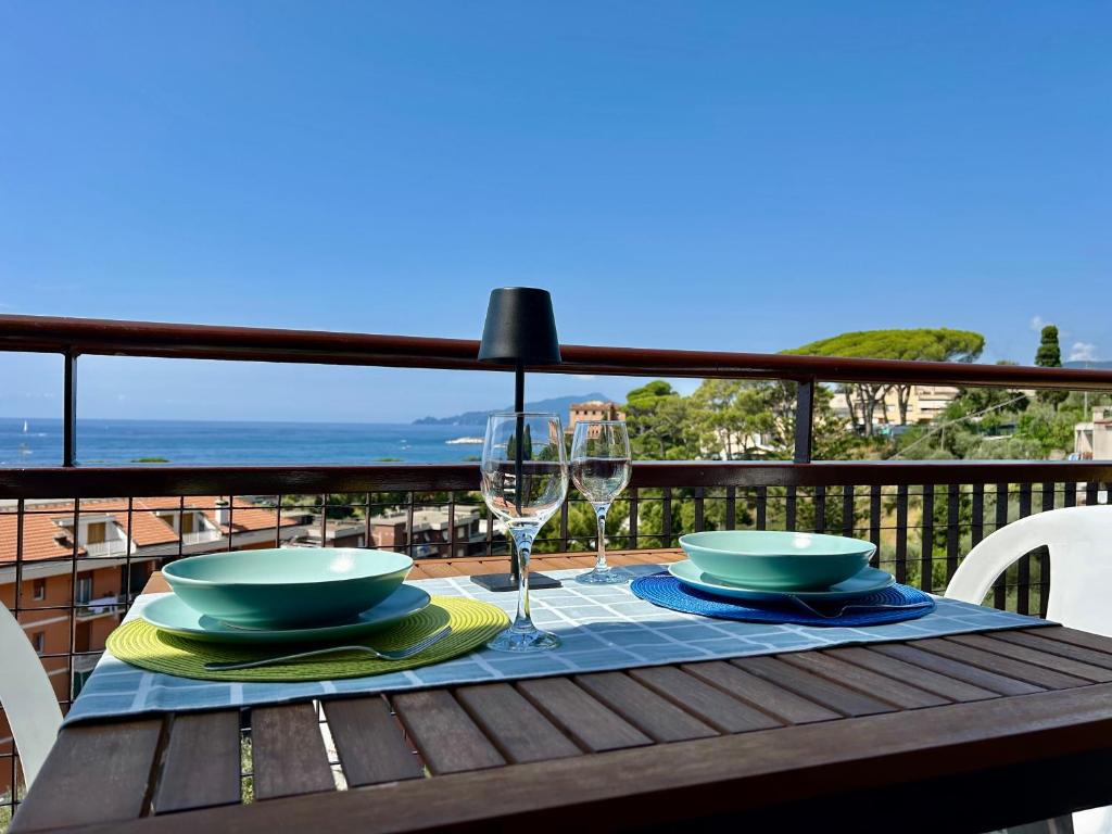 a table with a glass of wine on a balcony at Maison Panorama - Portofino View in Lavagna