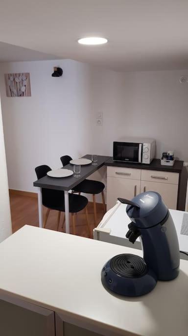 une pièce avec une cuisine avec une table et des chaises dans l'établissement Studio meublé en sous-sol en plein centre ville, à La Ferté-Bernard