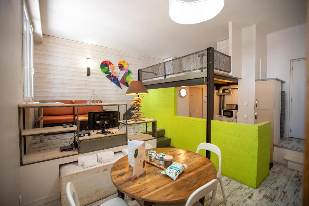 une chambre avec une table et une chambre avec une cuisine dans l'établissement La loge Theuriet - Bord de lac, à Annecy